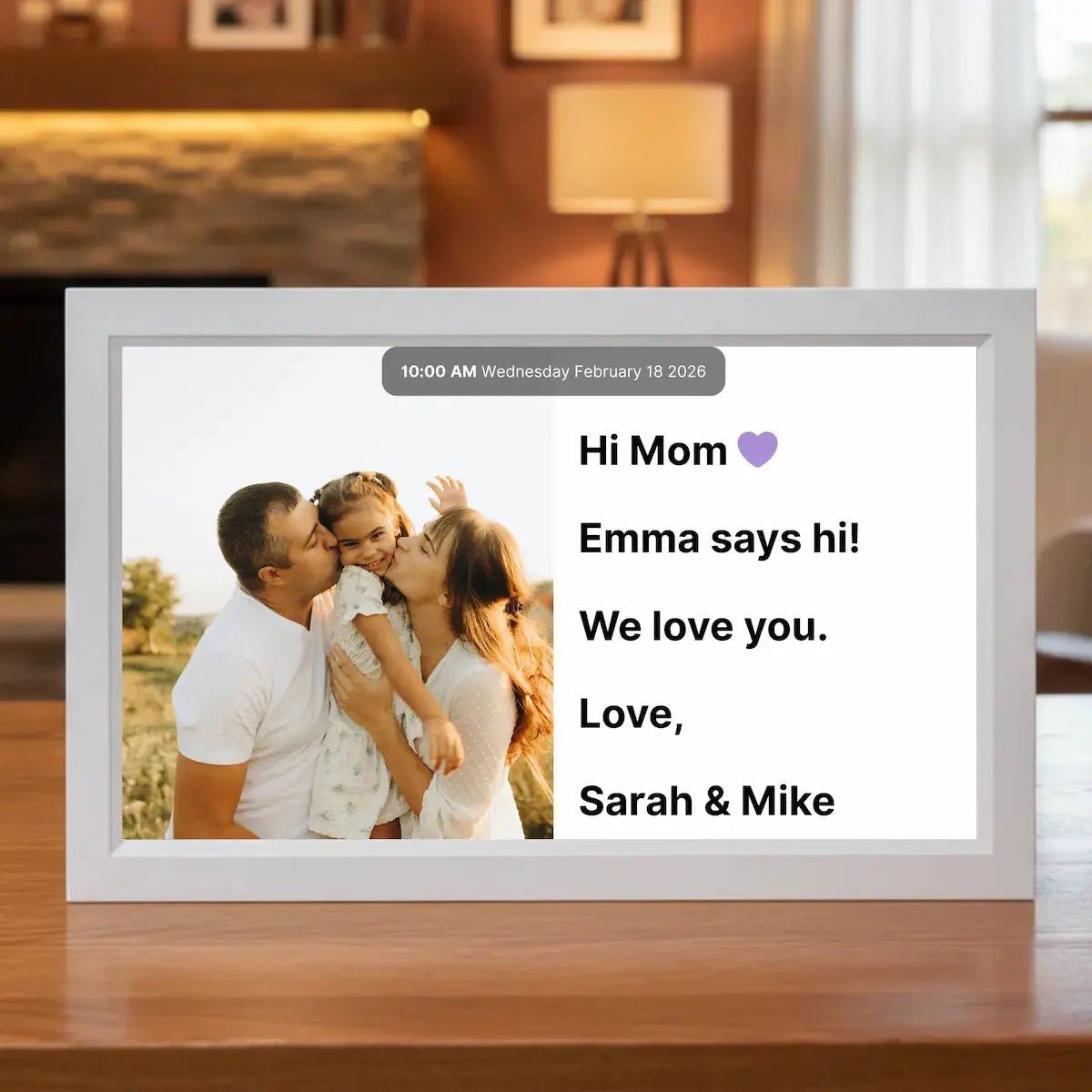 15 inch Memoryboard digital display on a table showing a family photo and a message that reads “Hi Mom 💜 Emma says hi! We love you. Love, Sarah & Mike.”